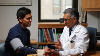 Doctor assisting a patient with a blood pressure monitoring device
